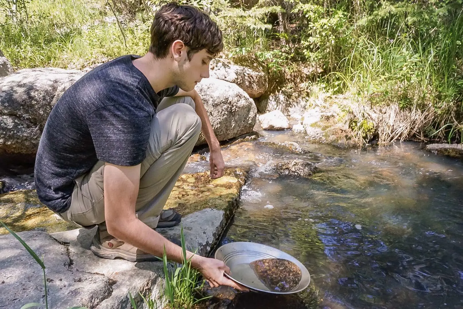 Boy panning for gold in Alaskan stream