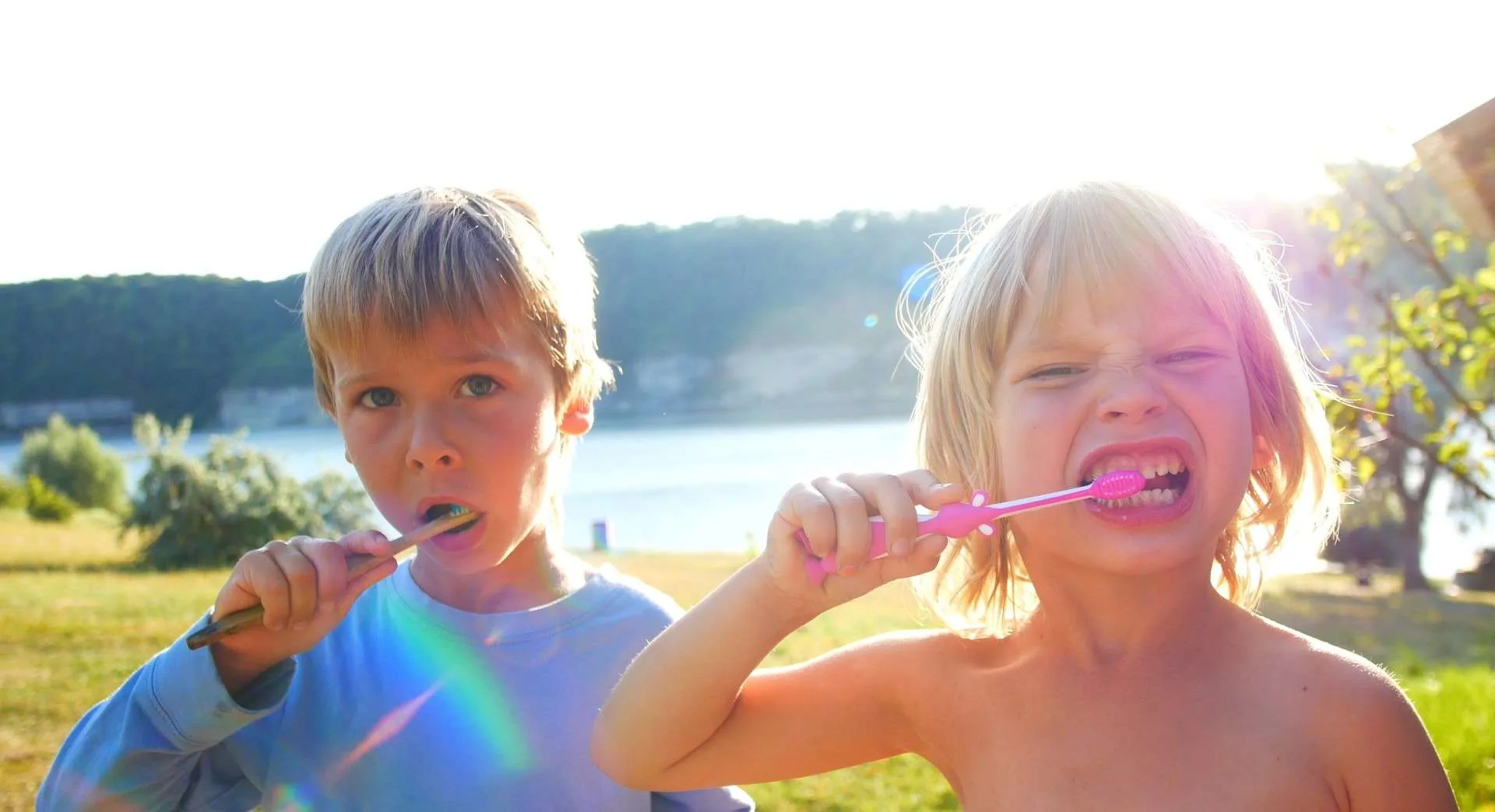 Two kids brushing teeth with toothbrush