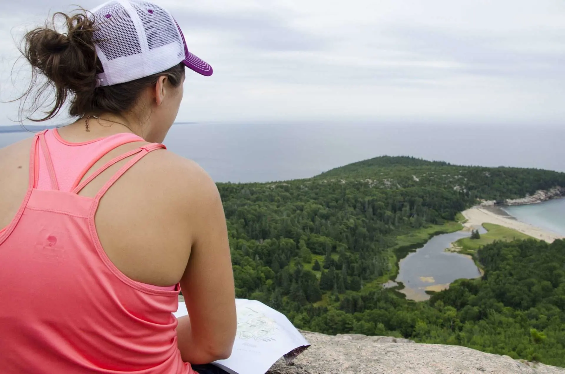 Woman sitting at lookout point after hiking in Acadia National Park