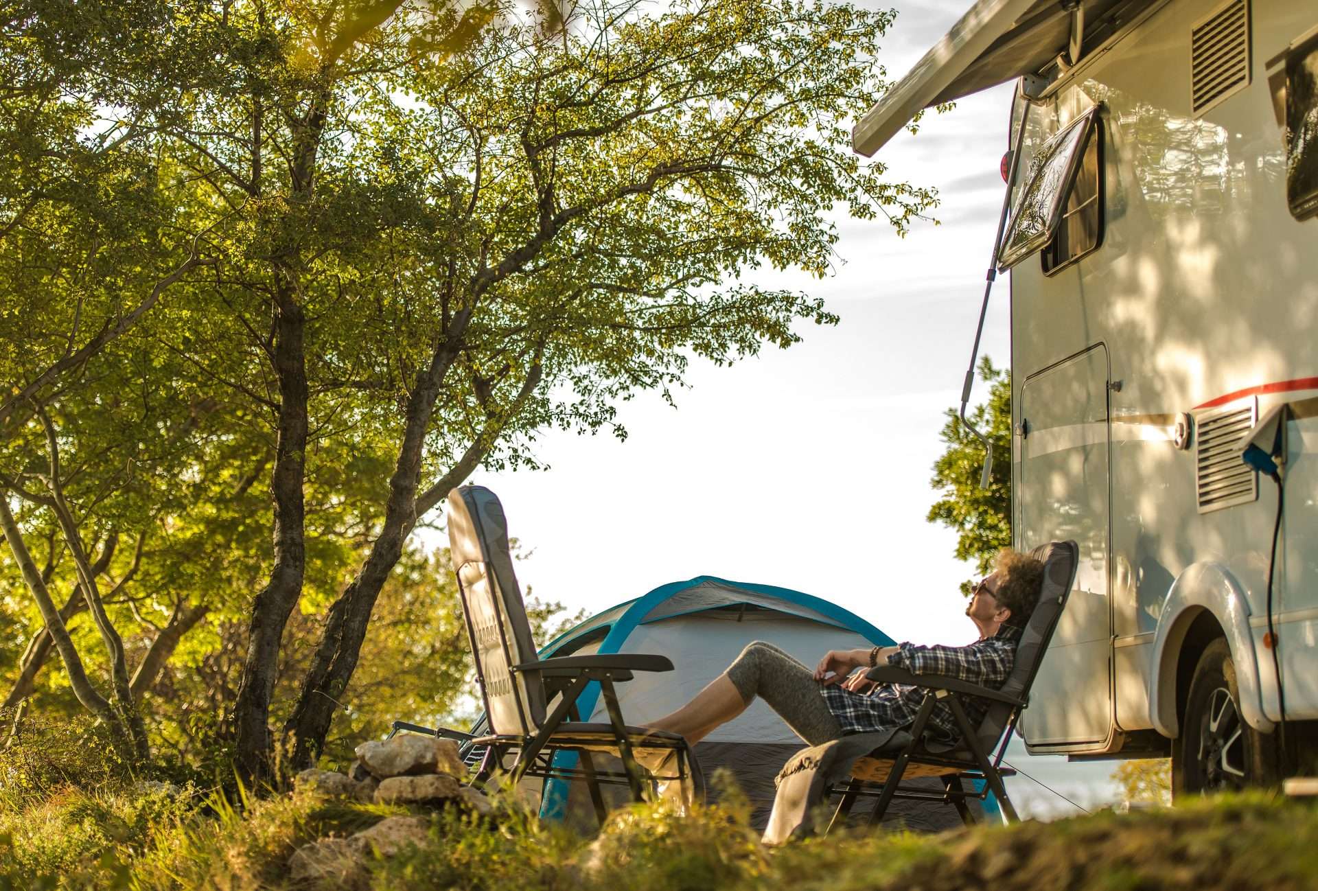 Woman relaxing in front of her RV while camping on an island.