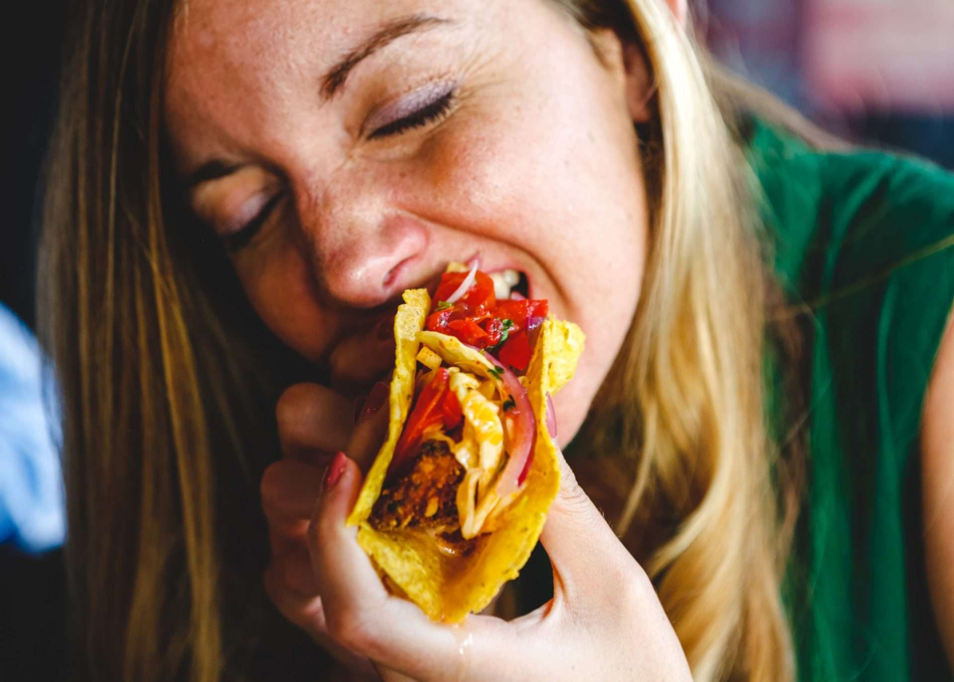 Woman taking a bite of a taco
