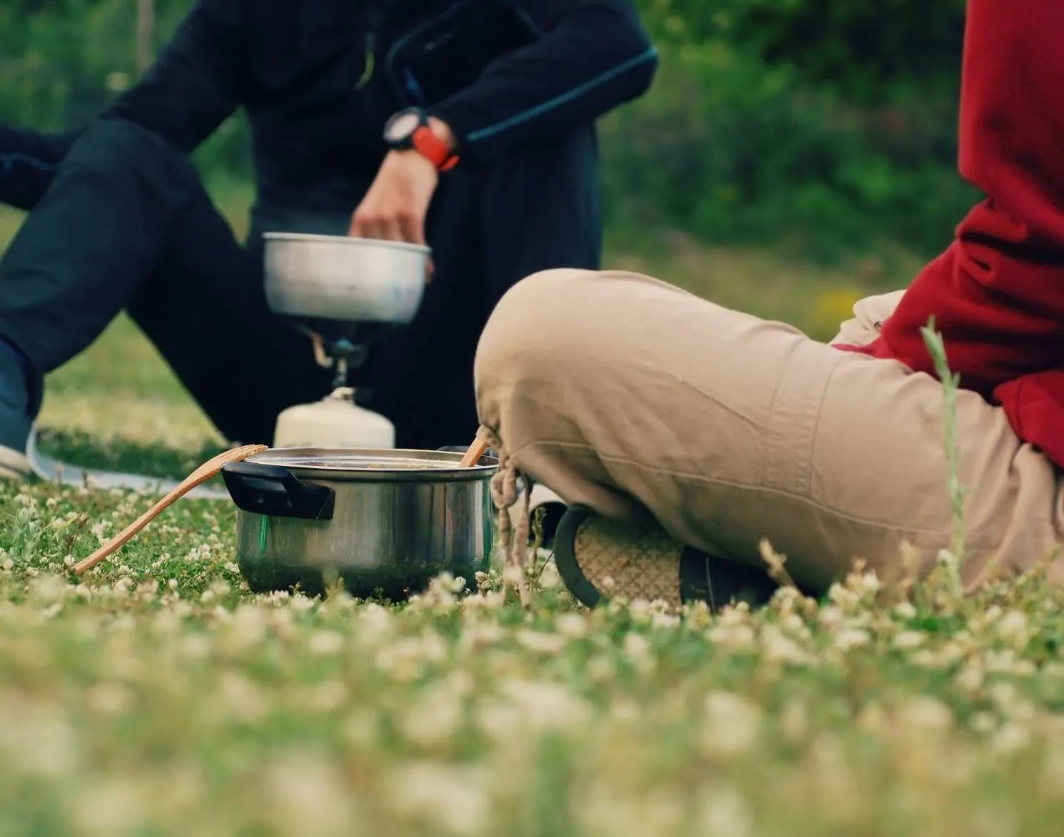 Couple cooking together over camping stove