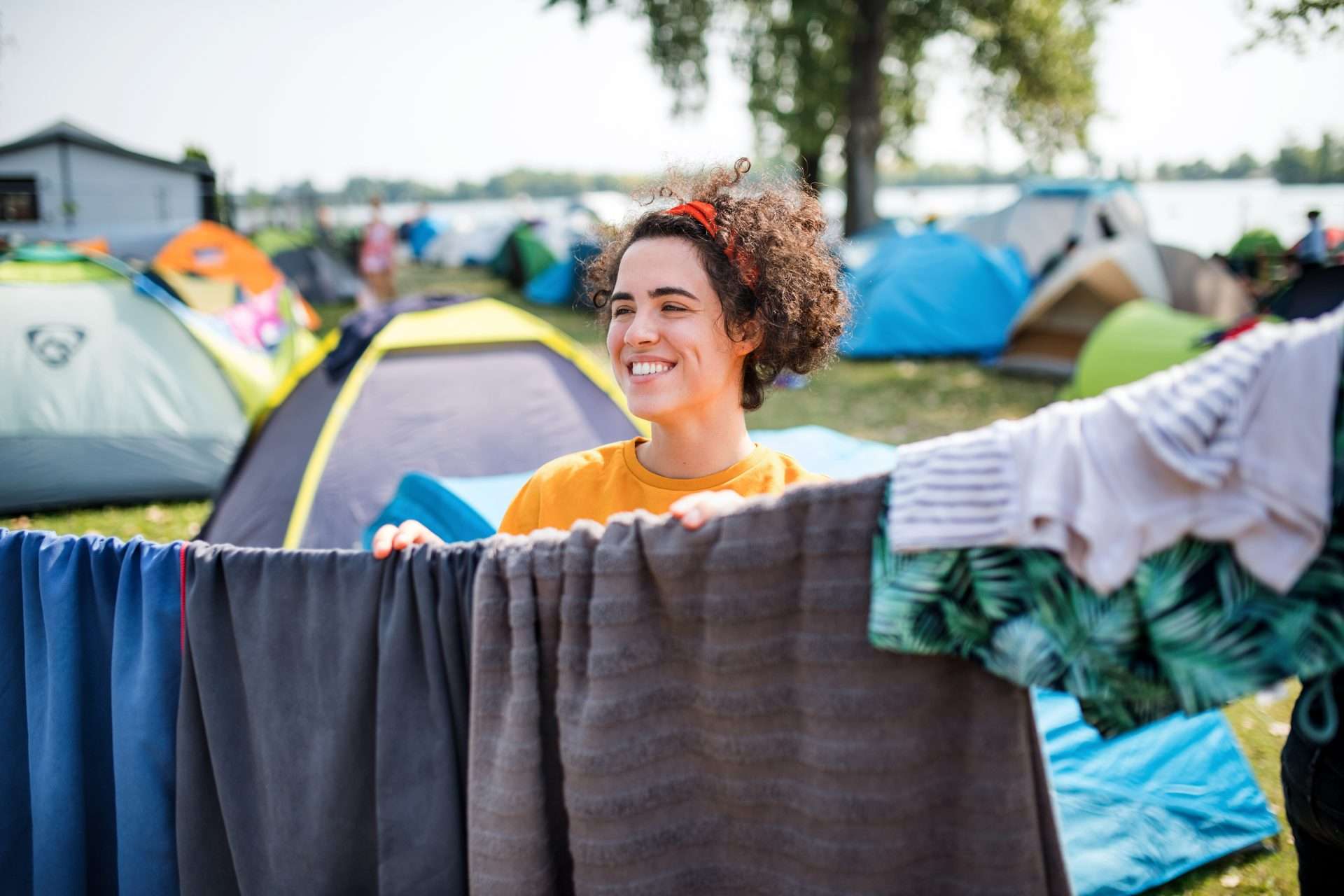Woman drying towels and clothes at campsite
