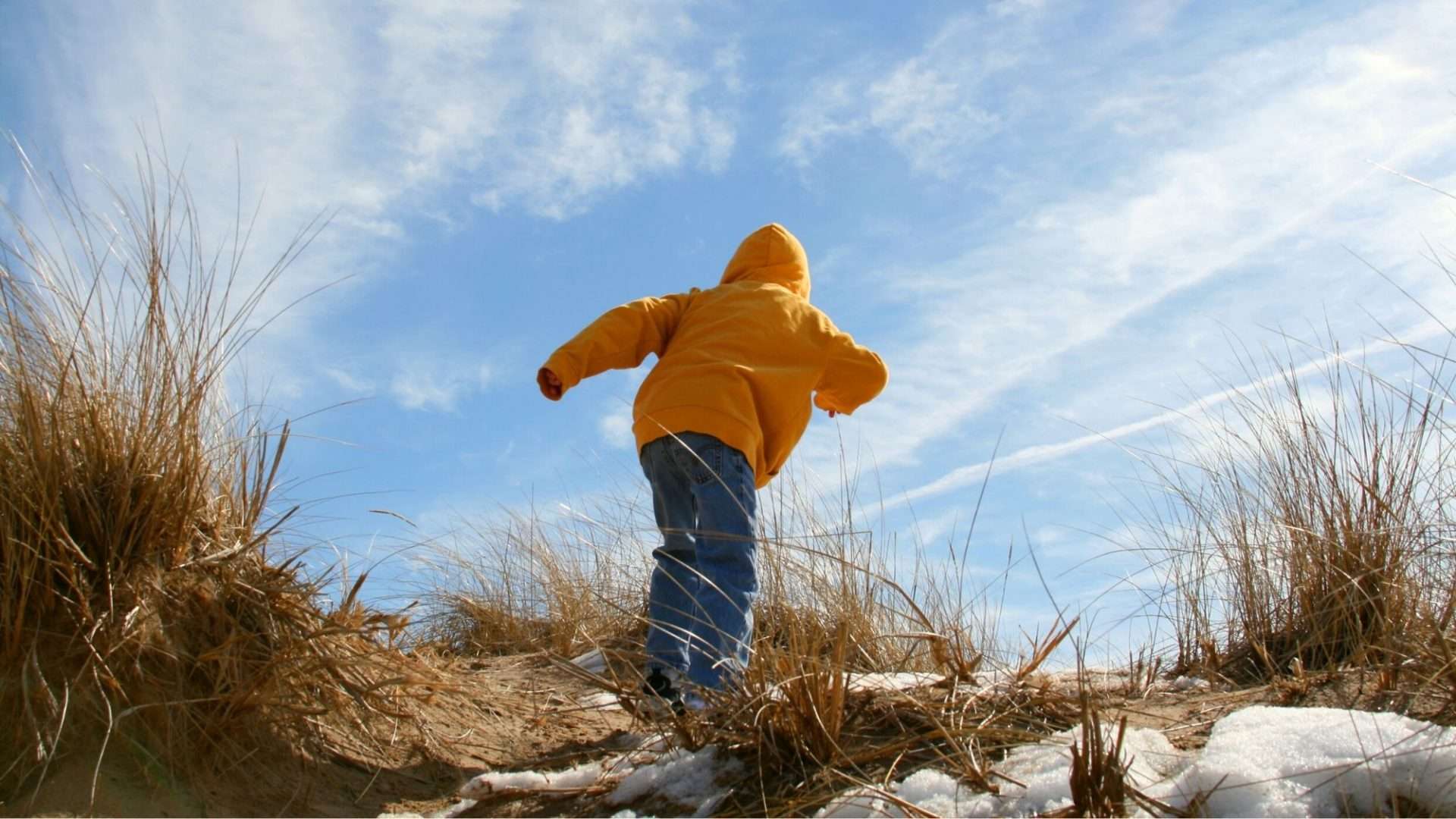 child climbing beach dunes on Lake Michigan