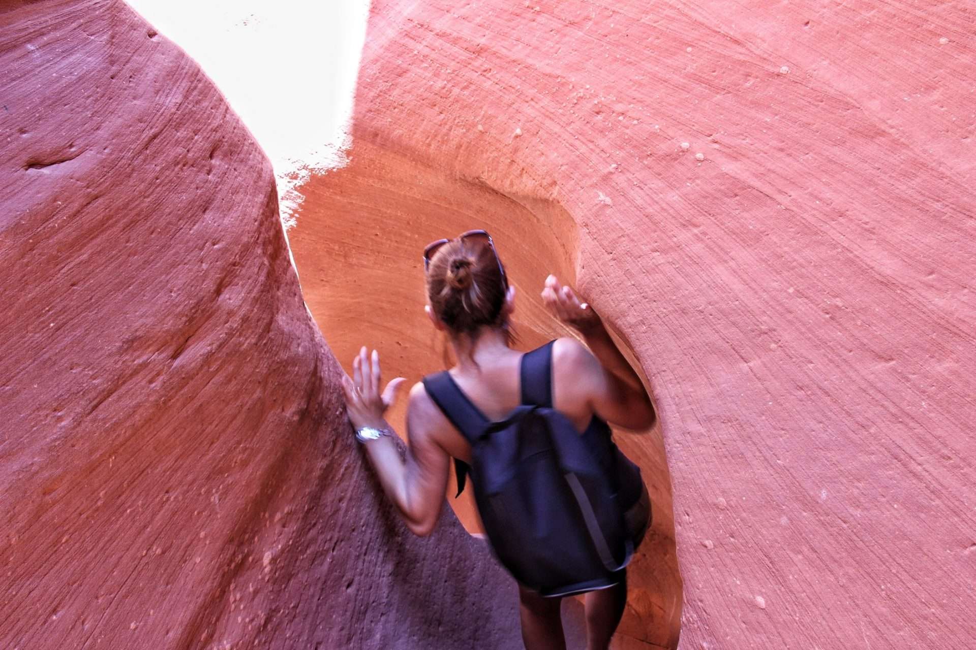 Woman walking through narrow slot canyon