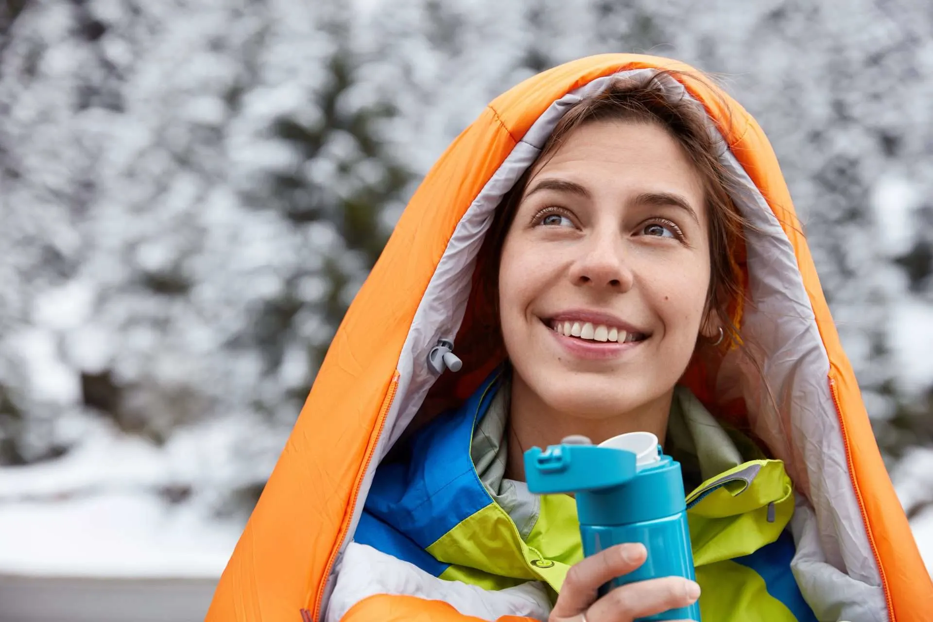 Woman smiling in sleeping bag in the snow