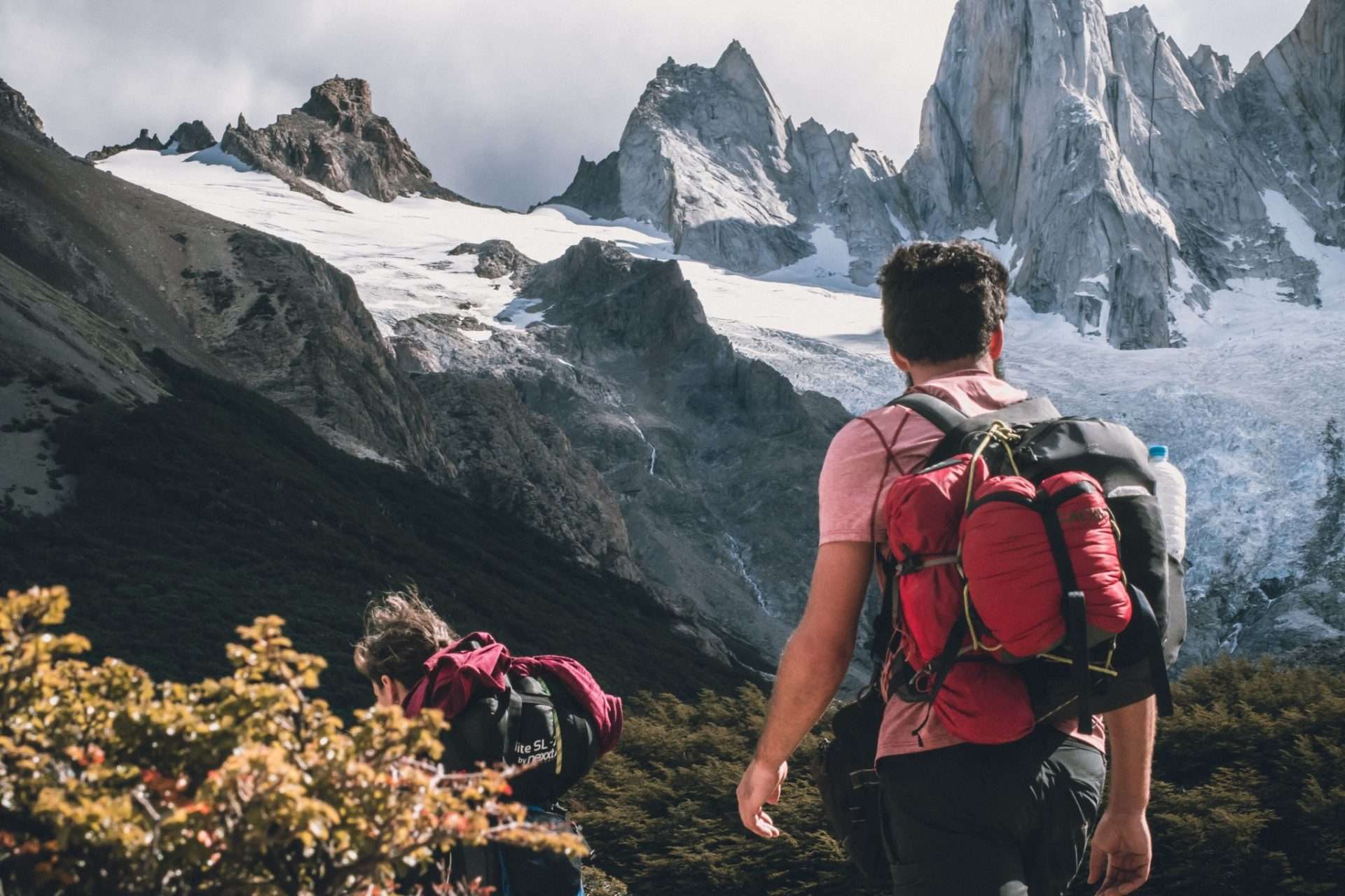 People hiking in snowy mountains with hiking pack