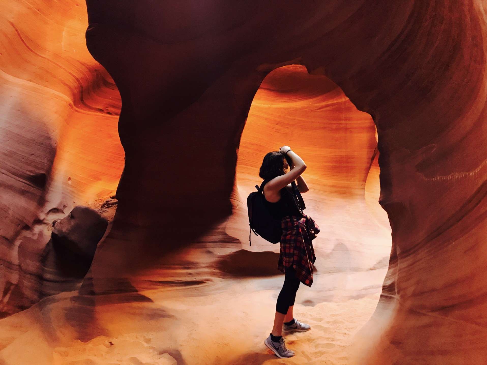 Woman taking a picture while on a tour of a slot canyon