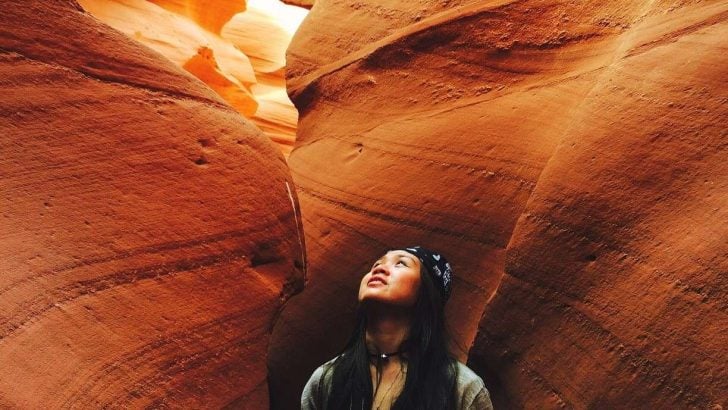 woman looking up in slot canyon