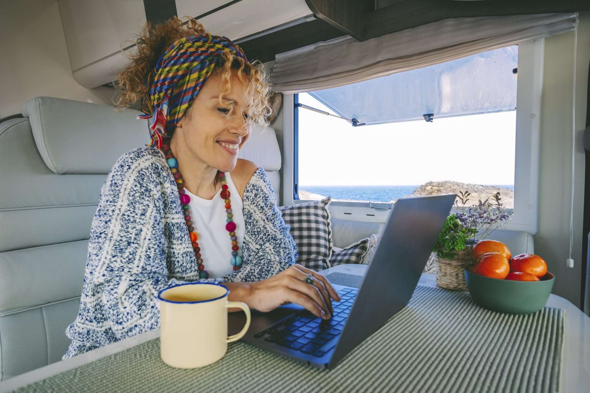 Woman using laptop inside of her RV to lookup VIN
