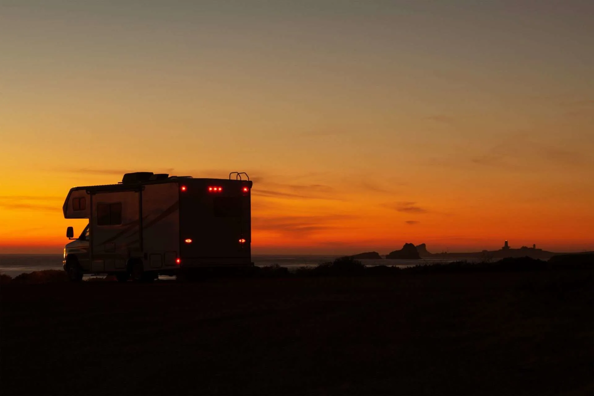 Class C RV parked off road at sunset