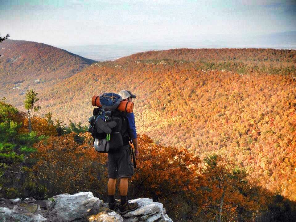 Man looking out at view point while hiking with backpack on the Appalachian Trail.