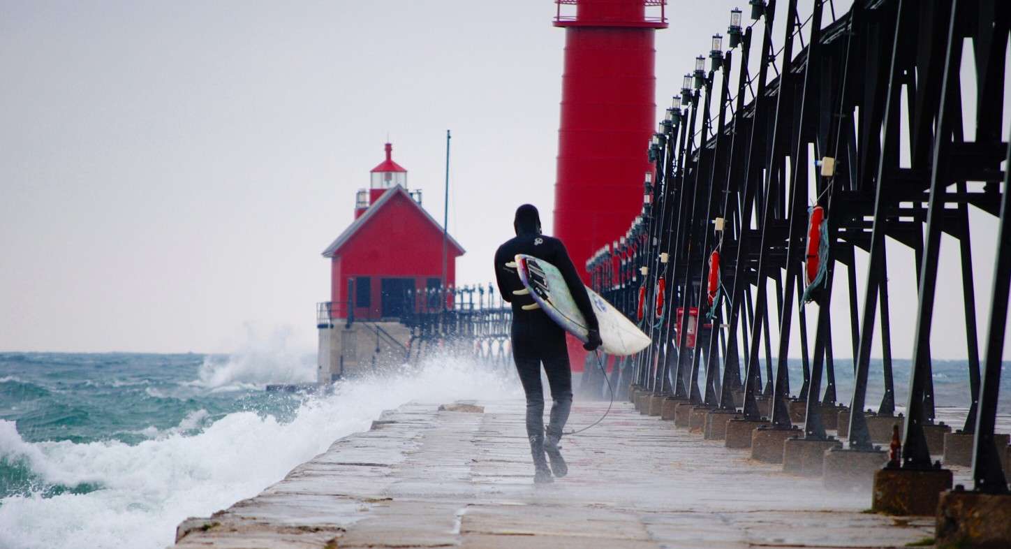 Surfer walking on pier in Grand Haven