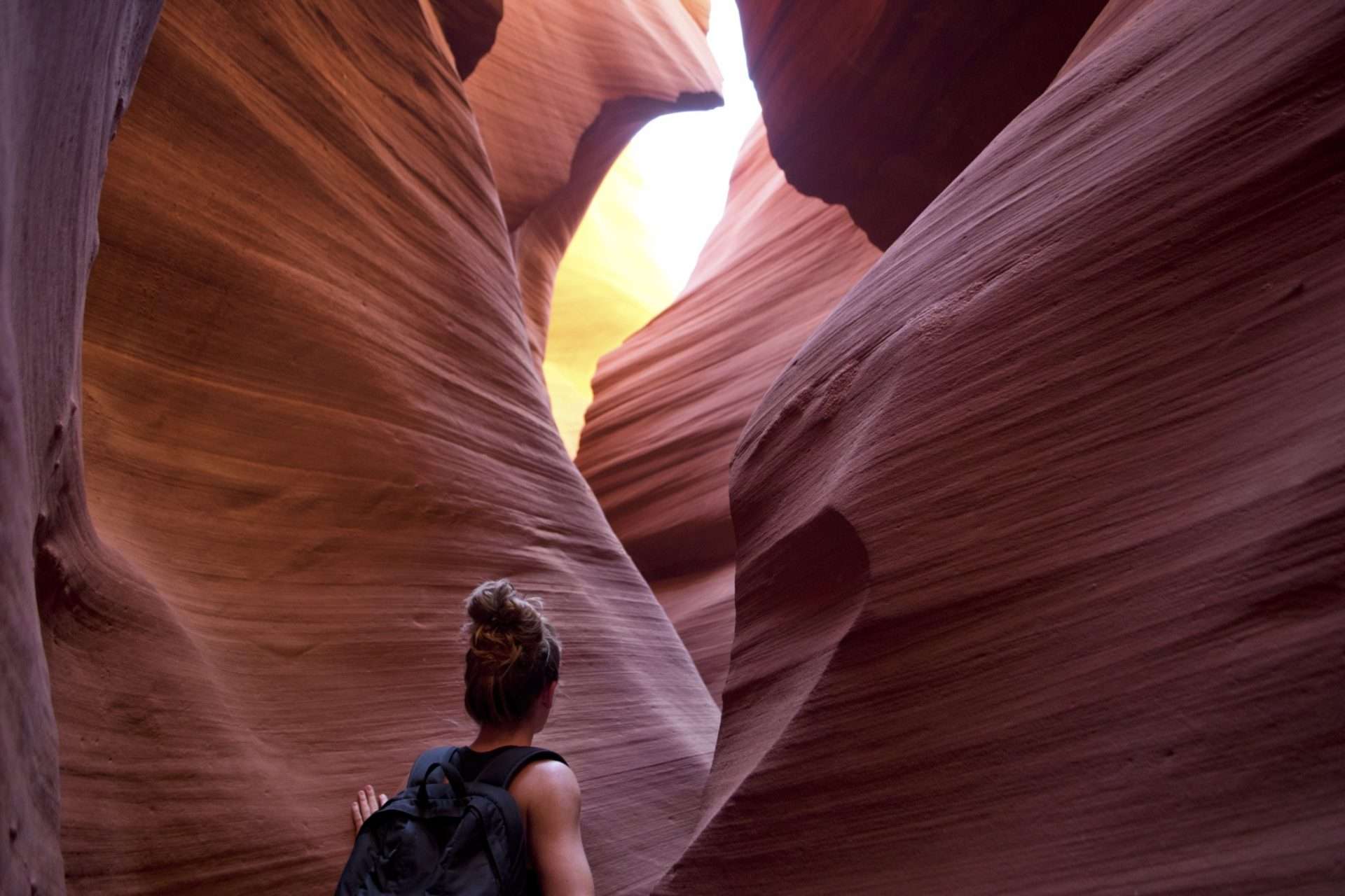 Woman hiking through a slot canyon.