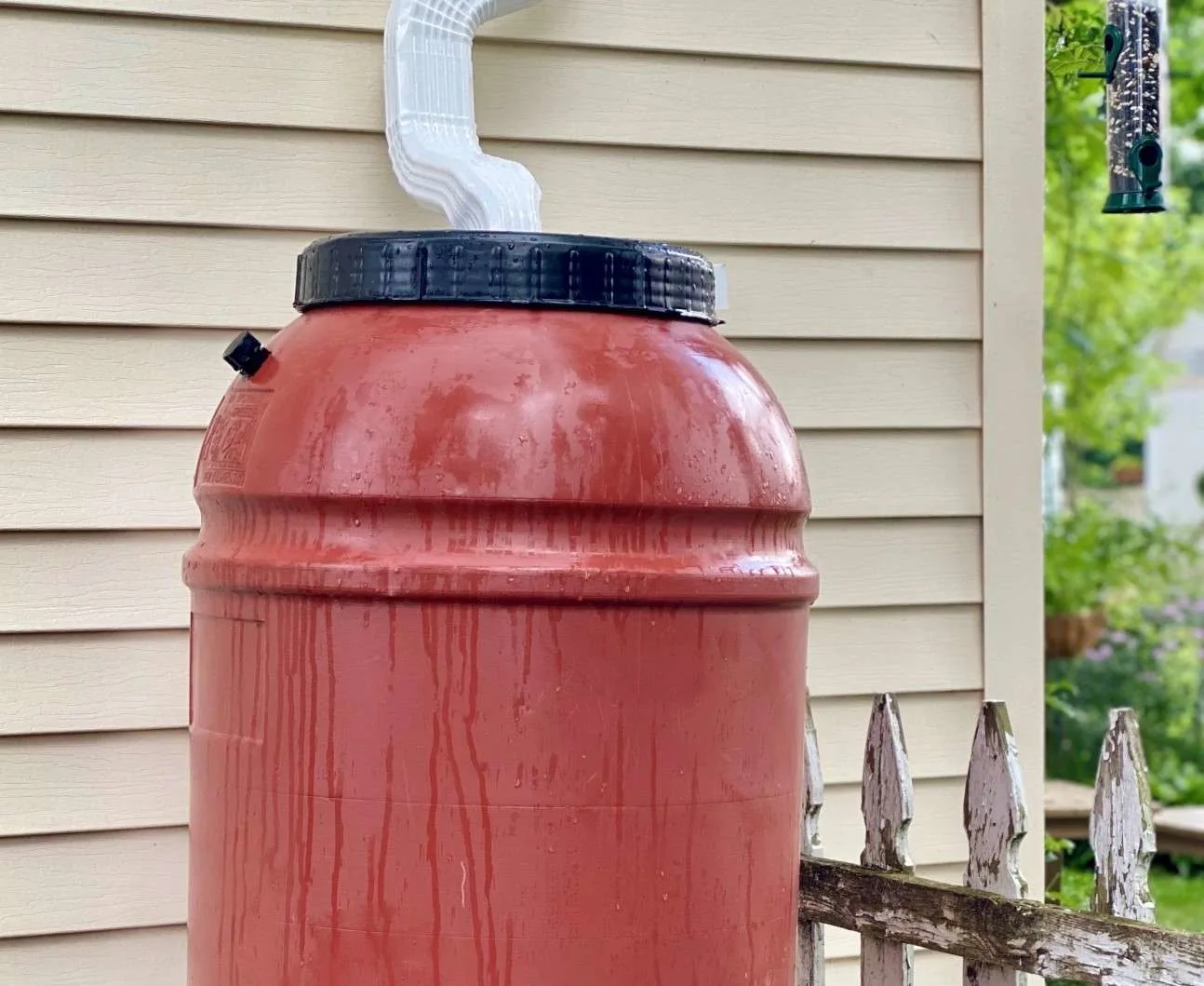 Close up of a rainwater collection tank next to a home