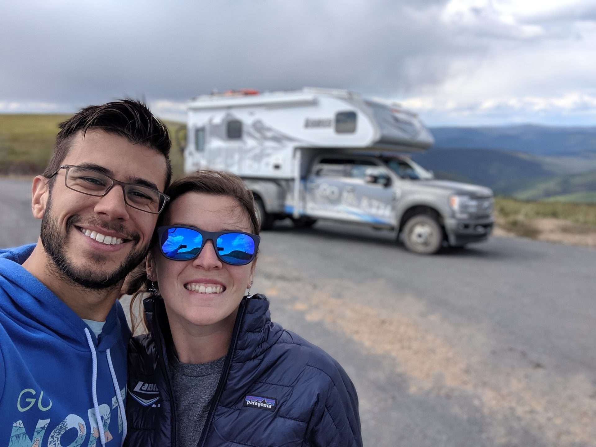 Tom and Cait from Mortons, a couple who RV, on the Move in front of truck camper in Alaska.