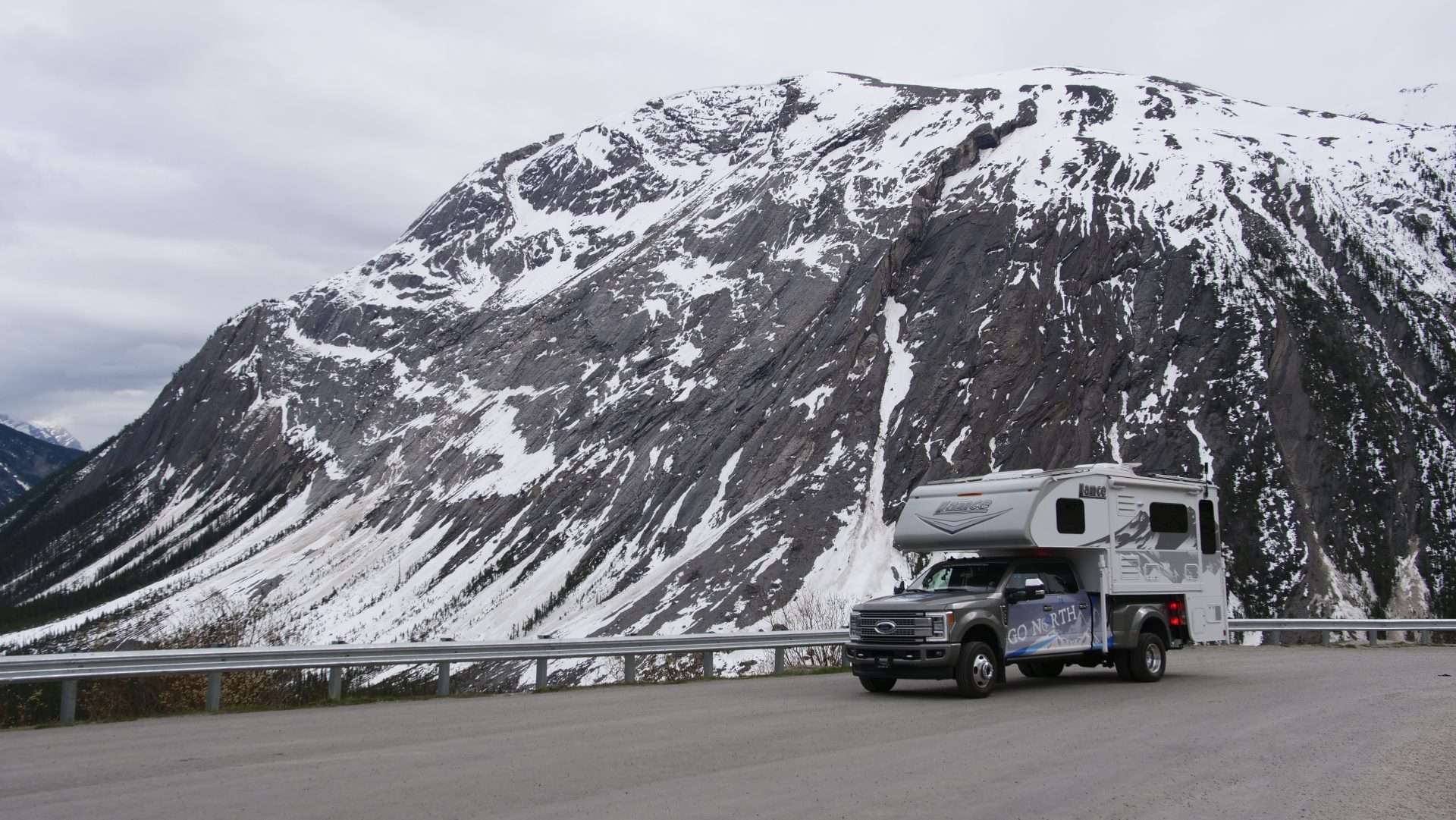 Mortons on the Move truck camper driving through Alaskan mountains.