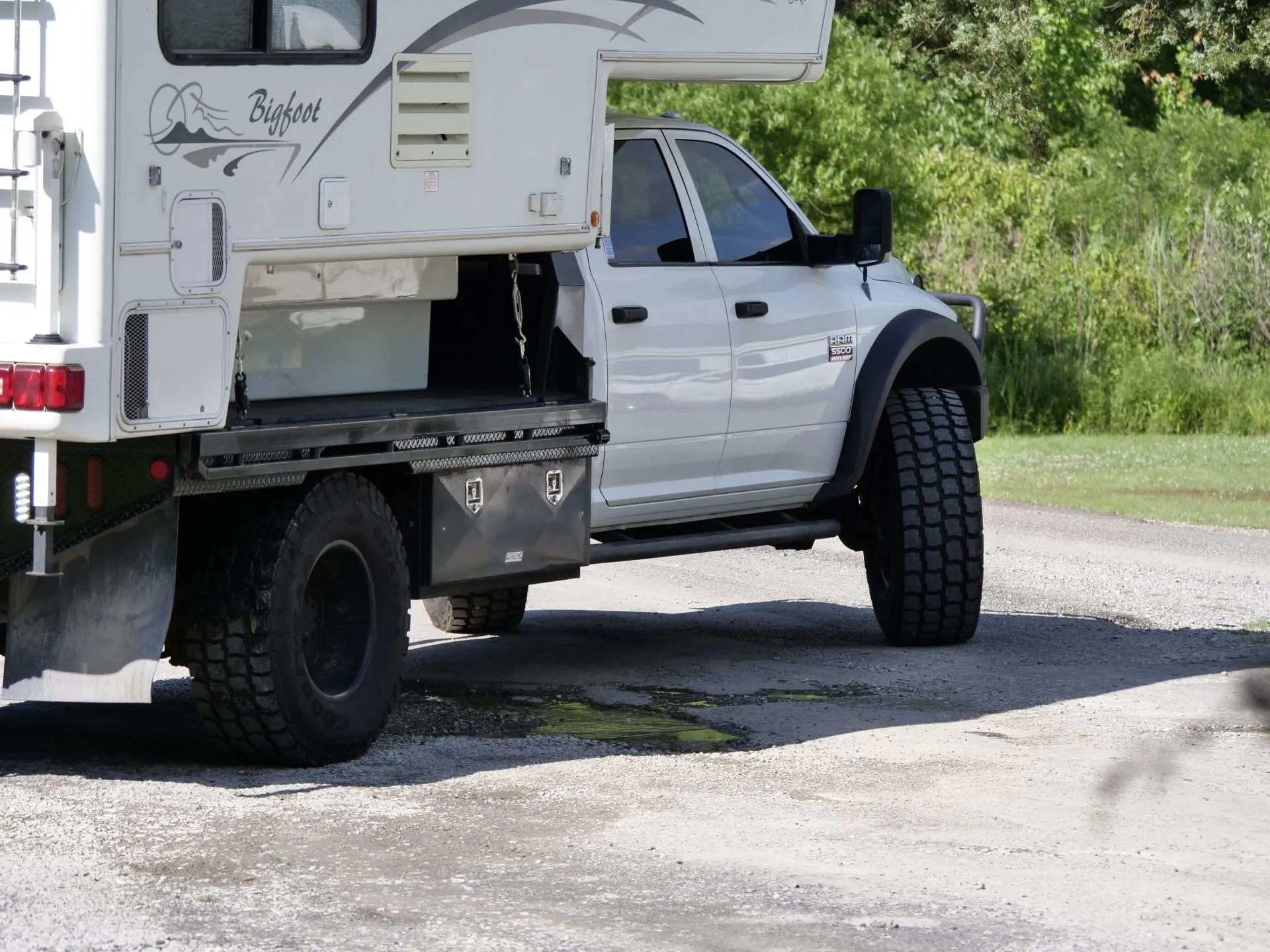 Truck with truck camper installed and large tire modification