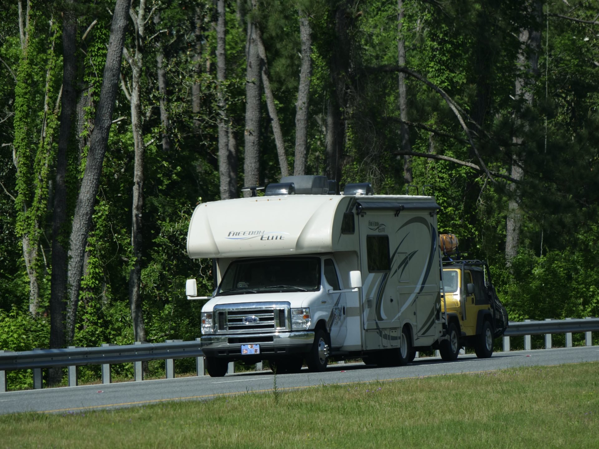 Class C RV towing Jeep
