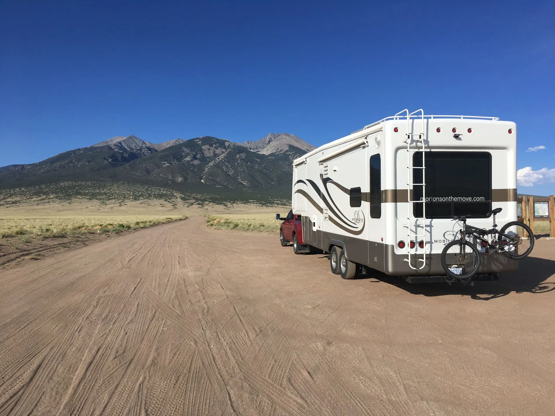 Mortons on the Move fifth wheel RV driving on dirt road.