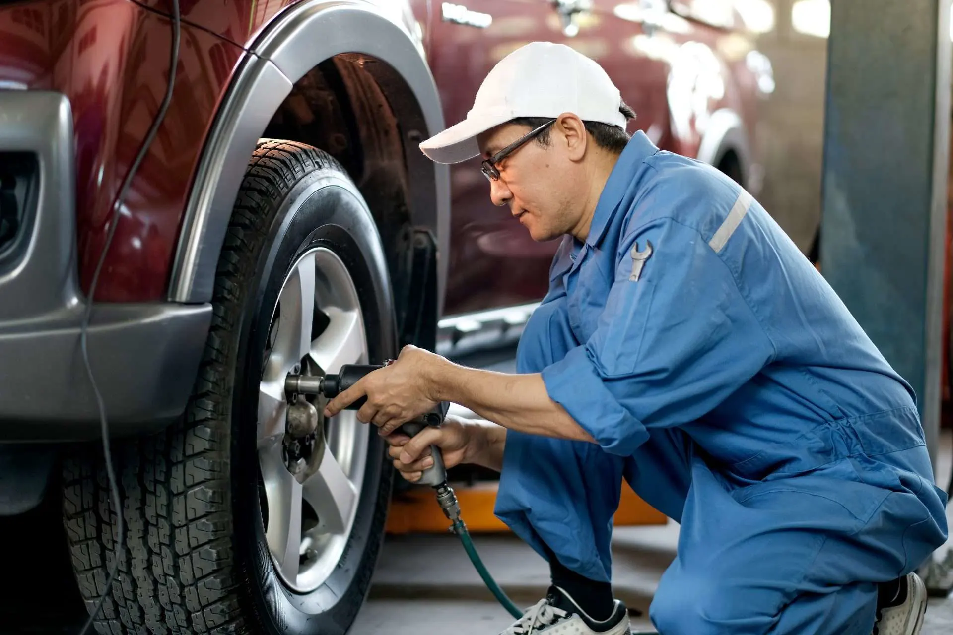 Mechanic installing bigger tires on truck