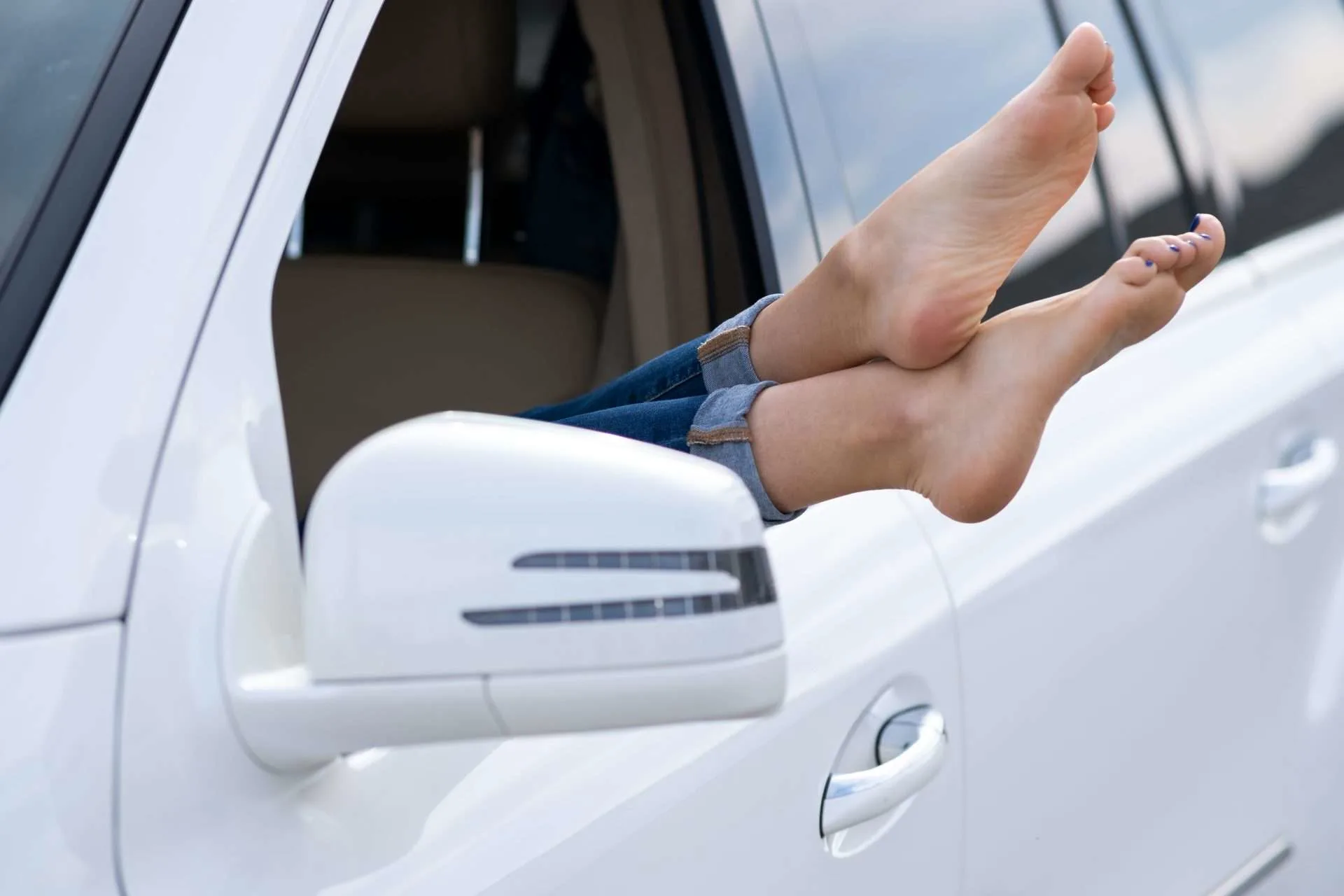 bare feet sticking out of car window