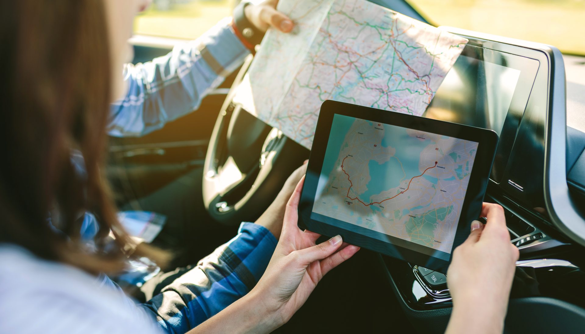 Woman comparing gps map and paper map for RV road trip.