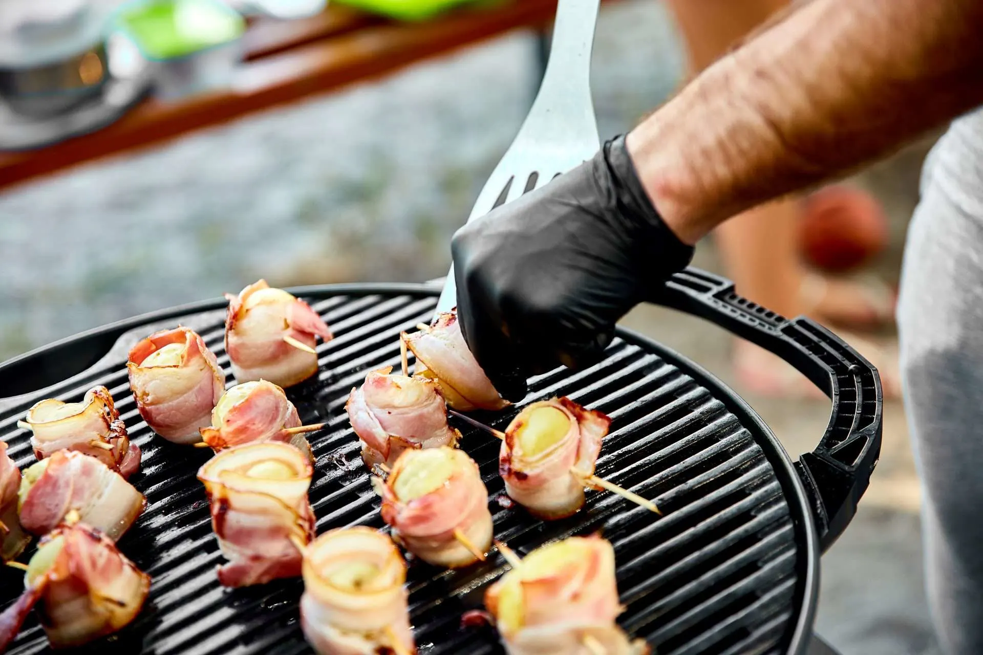 Bacon wrapped potatoes being made on grill