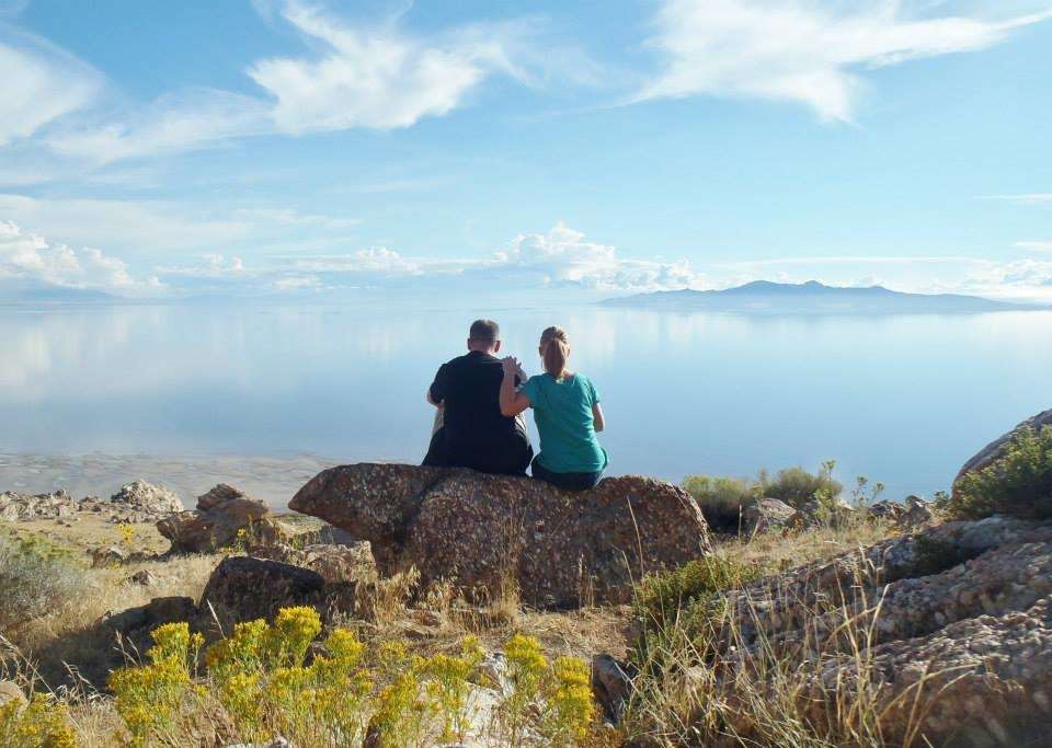 Couple sitting together on a rock looking out at Great Salt Lake