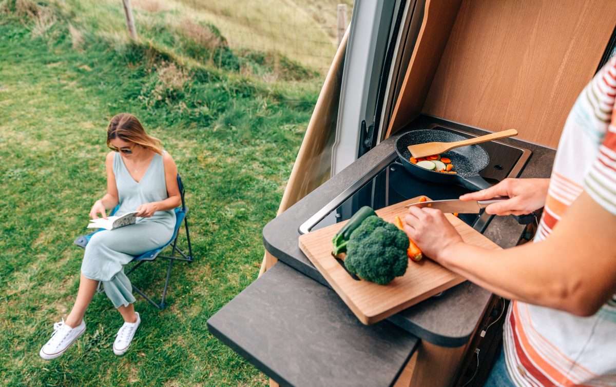 https://www.mortonsonthemove.com/wp-content/uploads/2022/07/man-cooking-vegetables-in-a-camper-van-while-woman-2022-05-30-17-15-11-utc-scaled.jpg