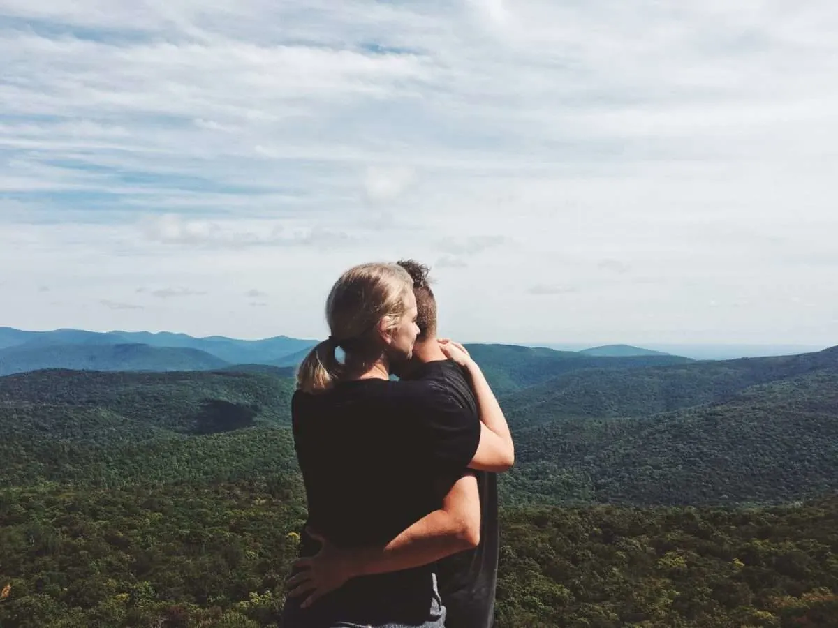 Couple hugging at the top of the Catskills while hiking