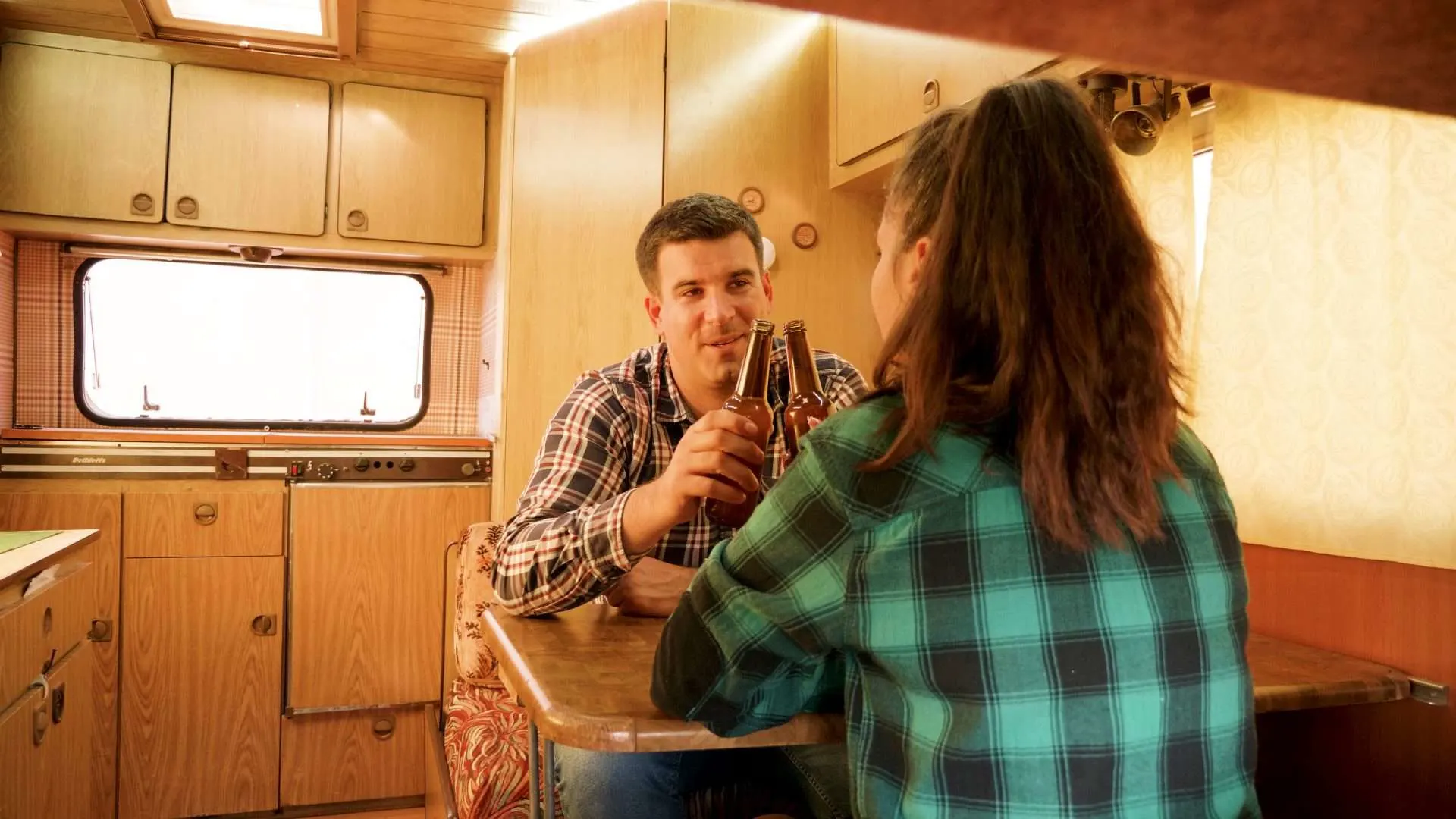 Man and woman drinking beer in RV renovation project