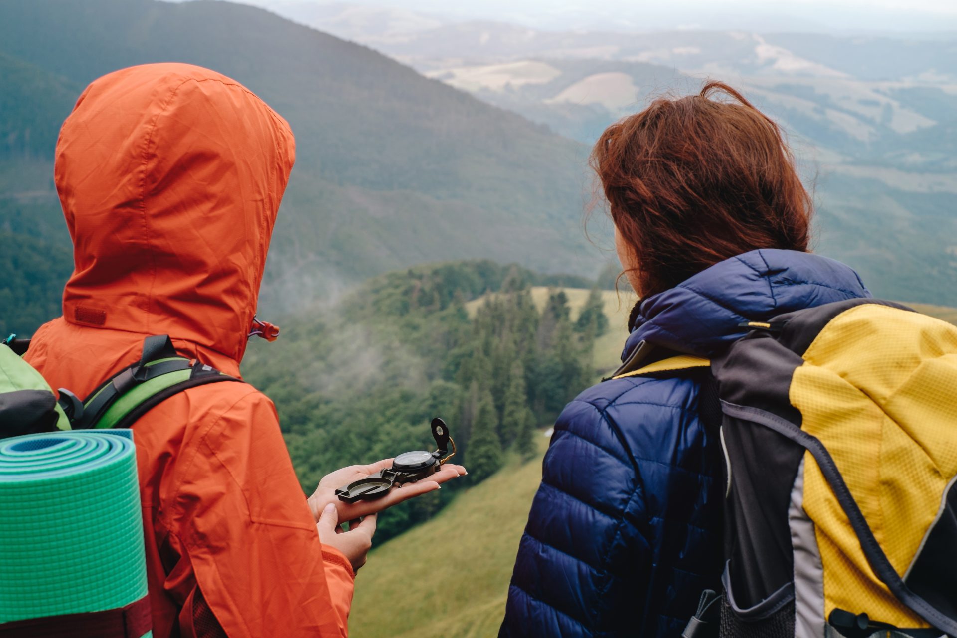 Two women navigating with a compass while hiking