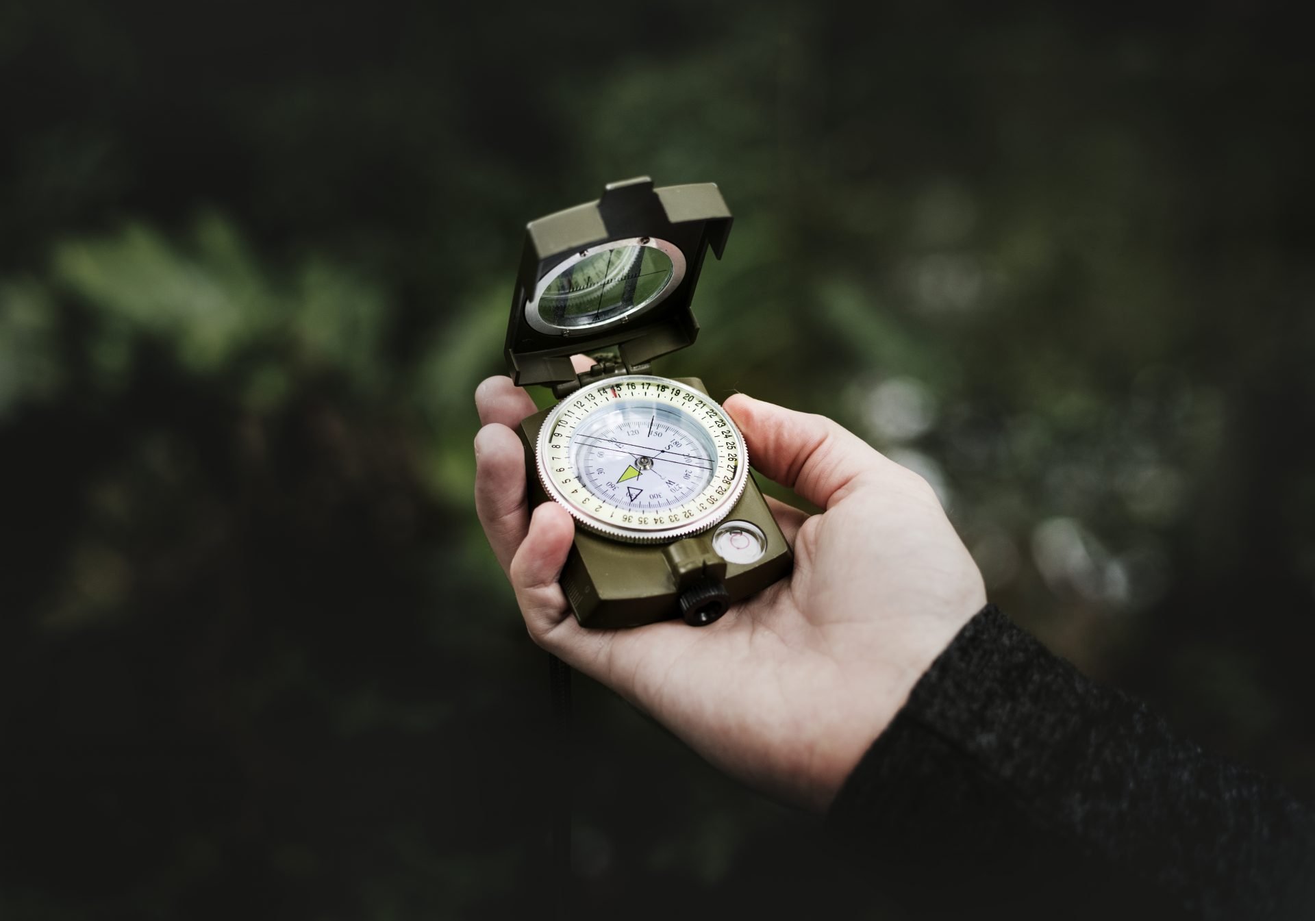 Hand holding compass while navigating