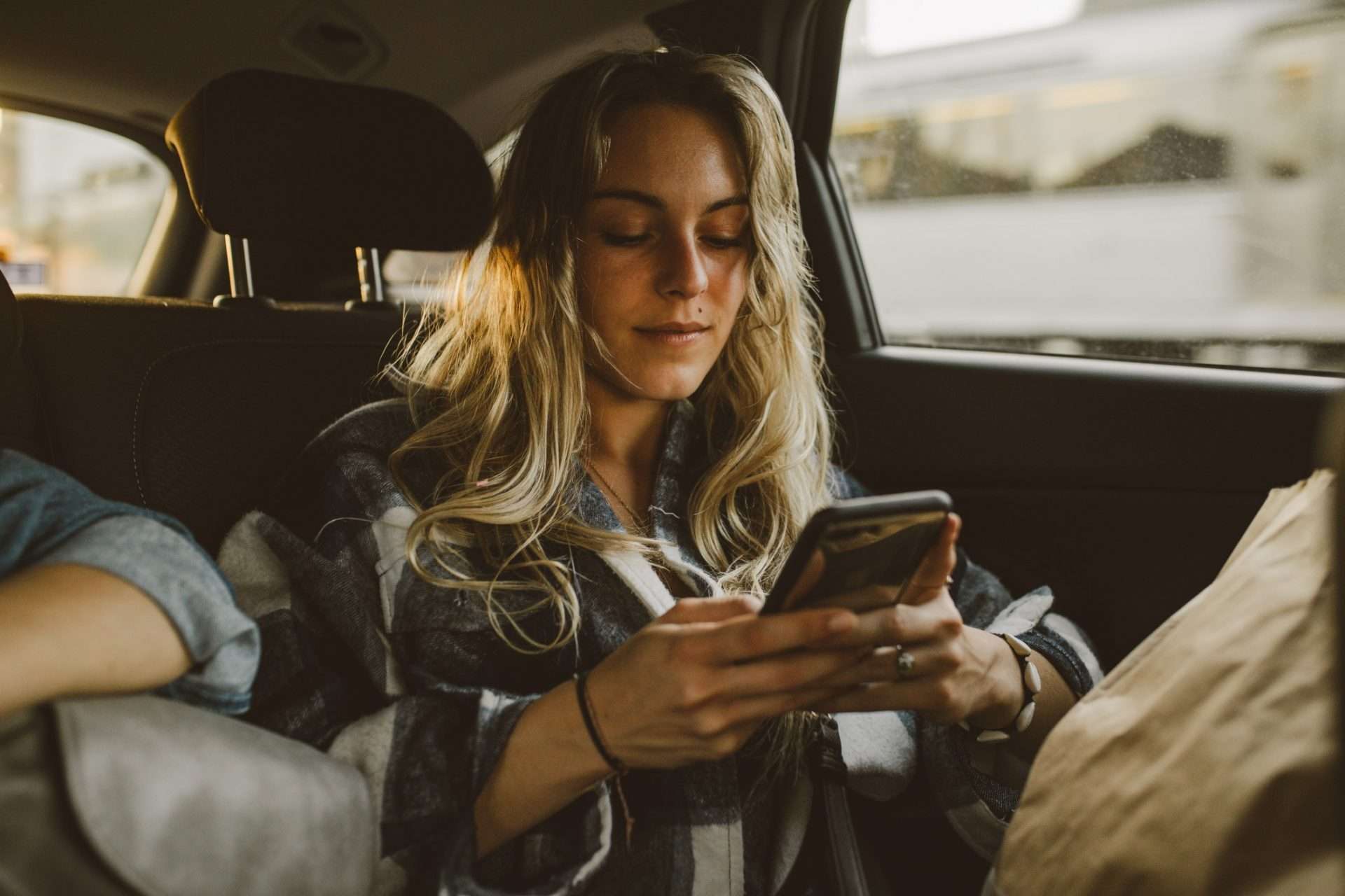Woman using phone while on a road trip