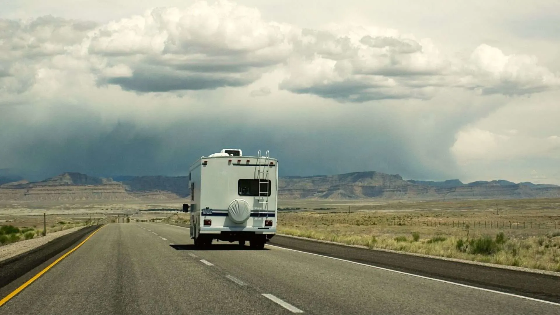 Class C RV driving towards storm clouds