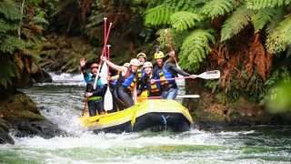 people standing up while white water rafting