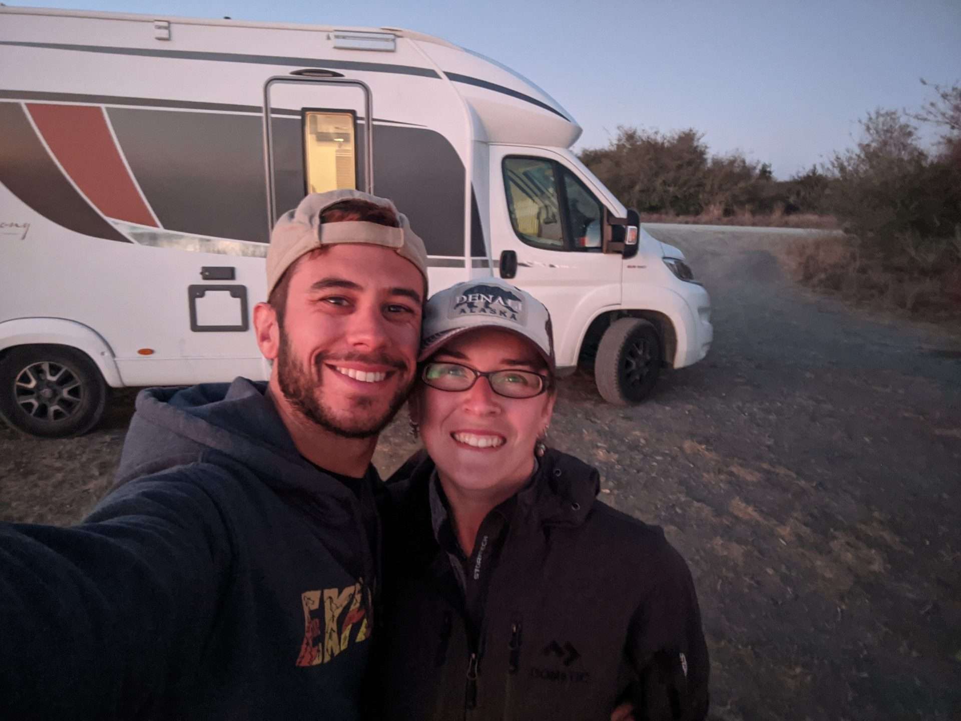 Tom and Cait from Mortons on the Move selfie in front of camper van.