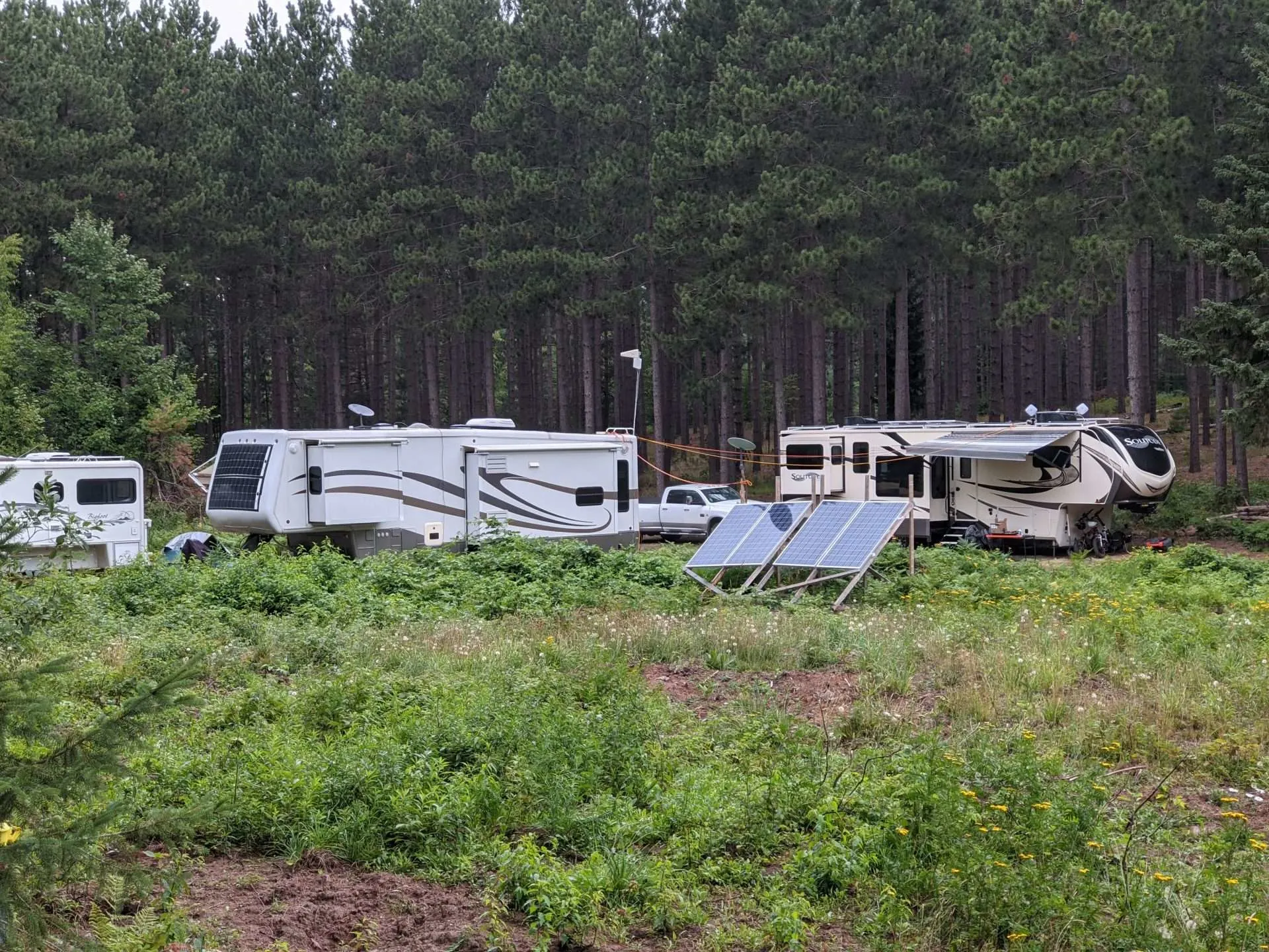RVs parked at campsite with solar panels installed on roof and in front of RV