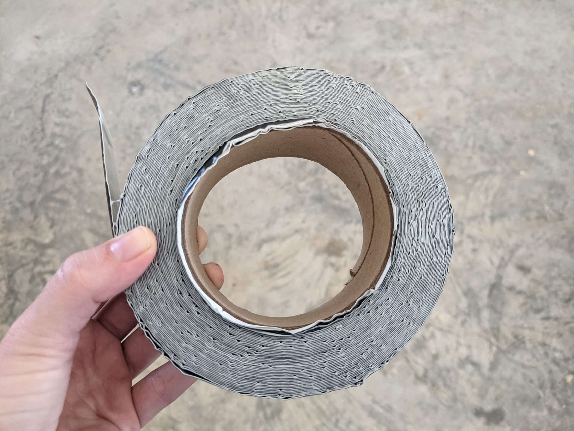 Person holding a roll of butyl tape