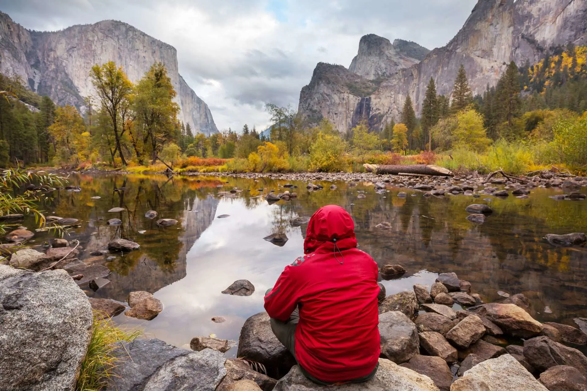 Man looking at lake and mountain view in the fall in Yosemite National Park, California, USA