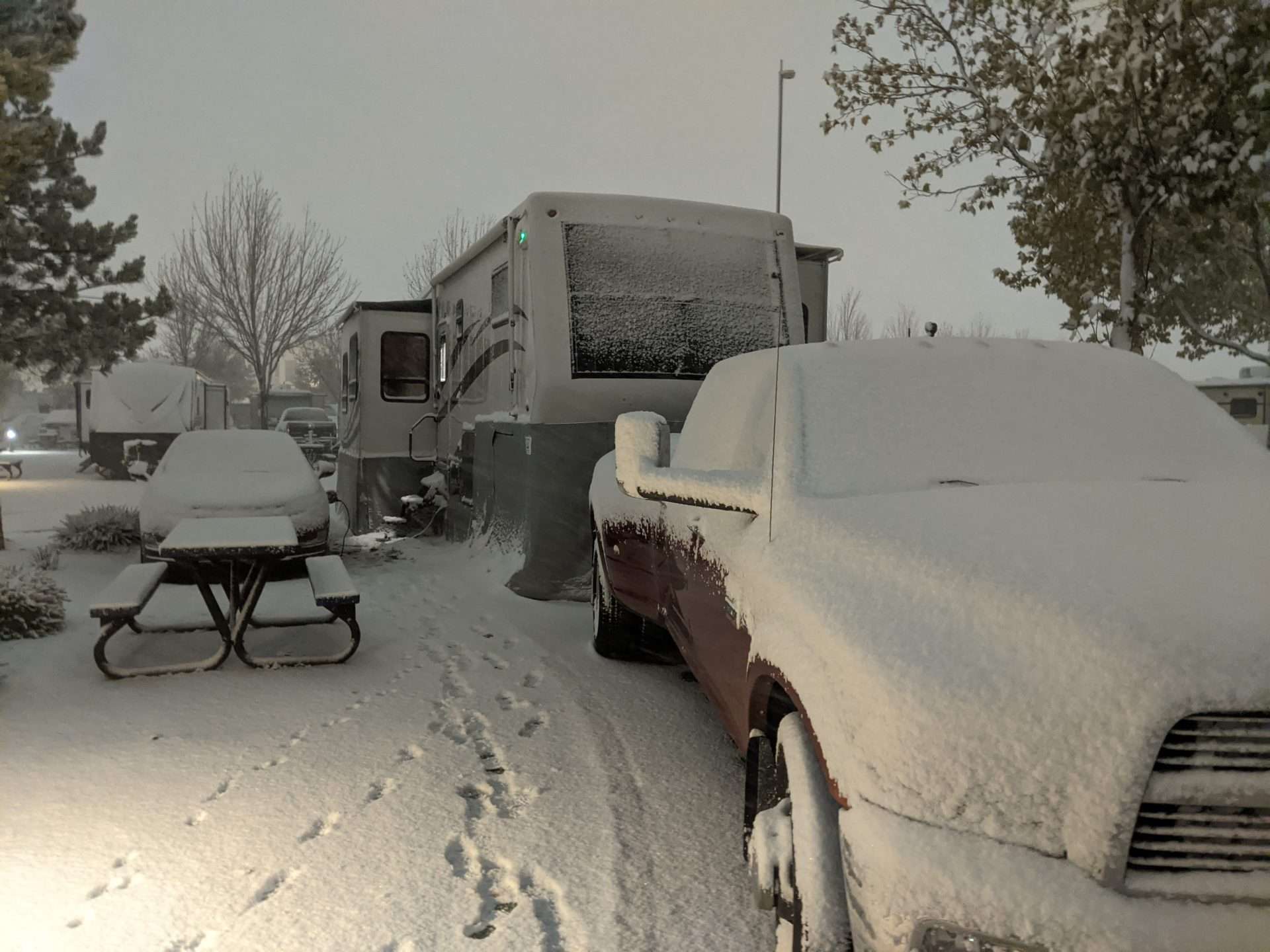 Class C motorhome parked in snow with just a snow skirt on