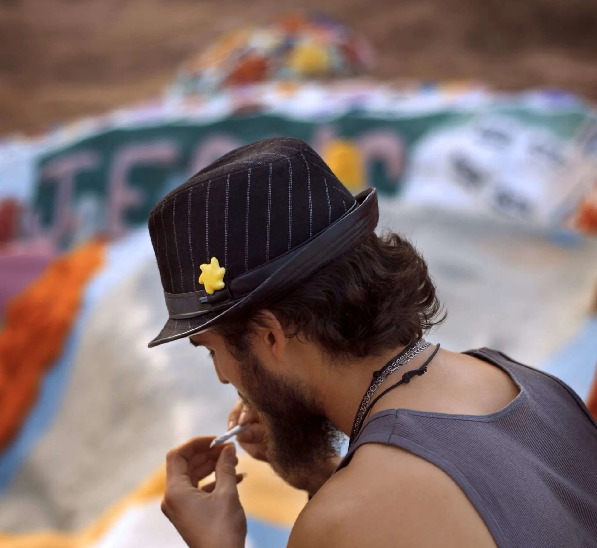 Man rolling joint in front of Salvation Mountain