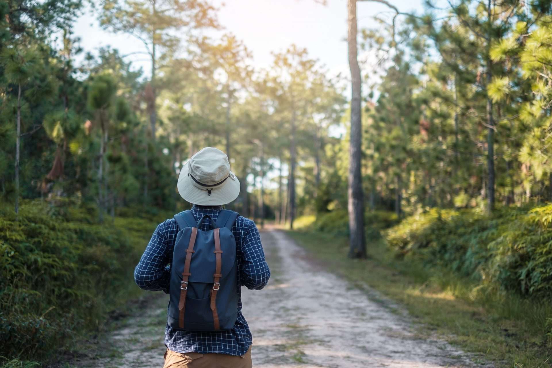 Man hiking on trail while wearing hiking hat