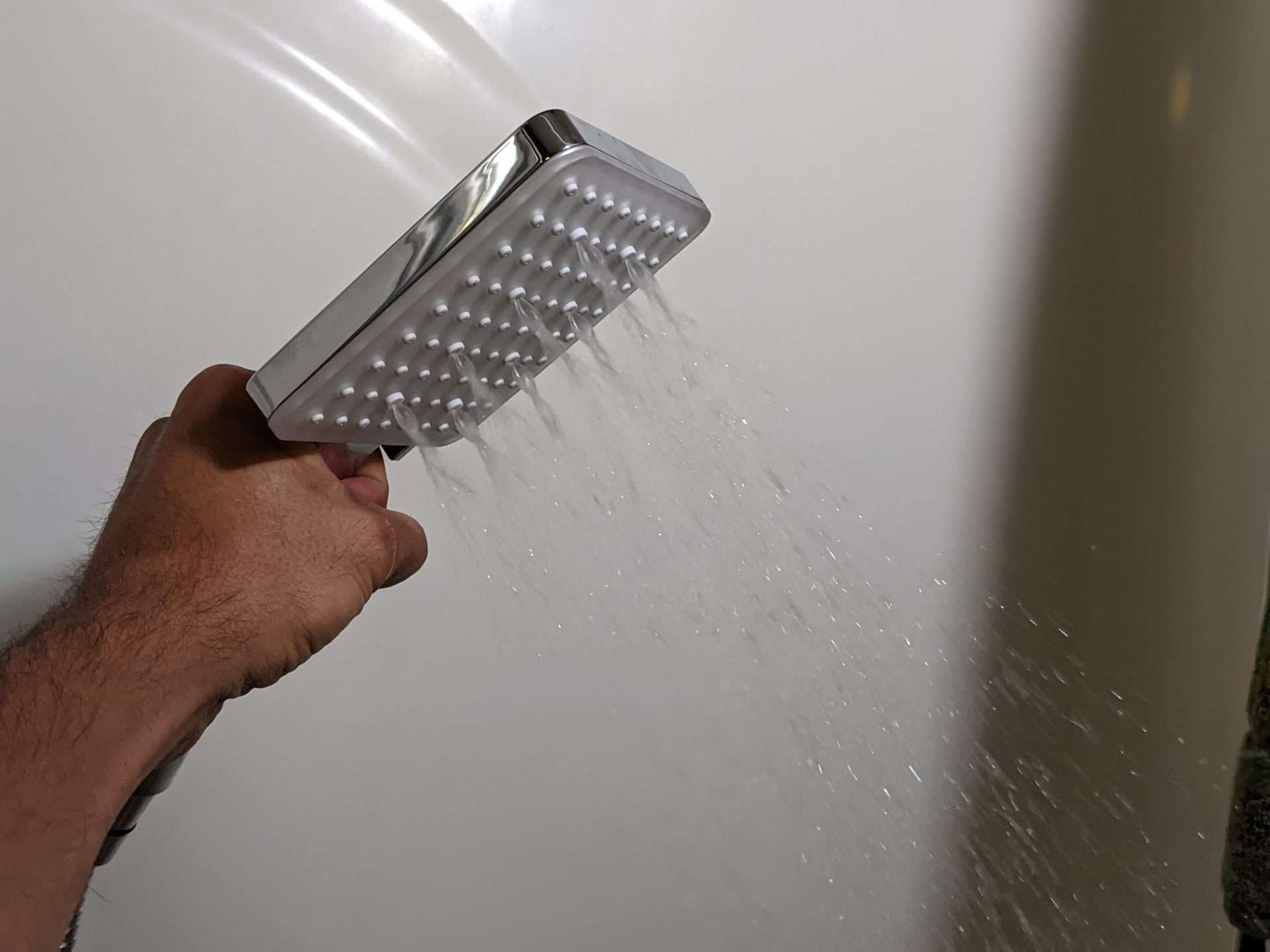 Man holding shower head in RV shower