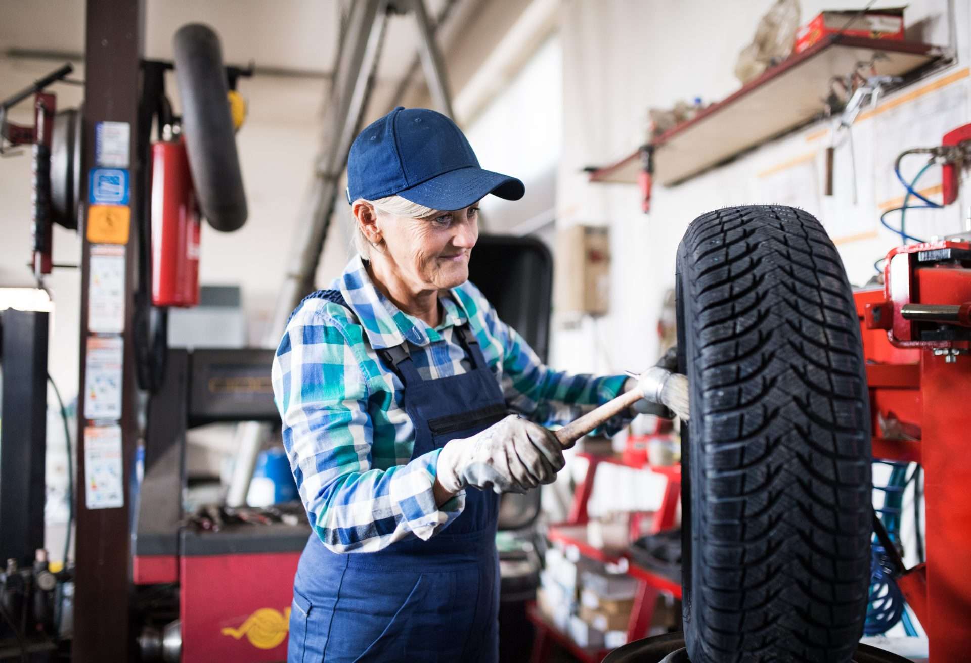Older female mechanic truing tire