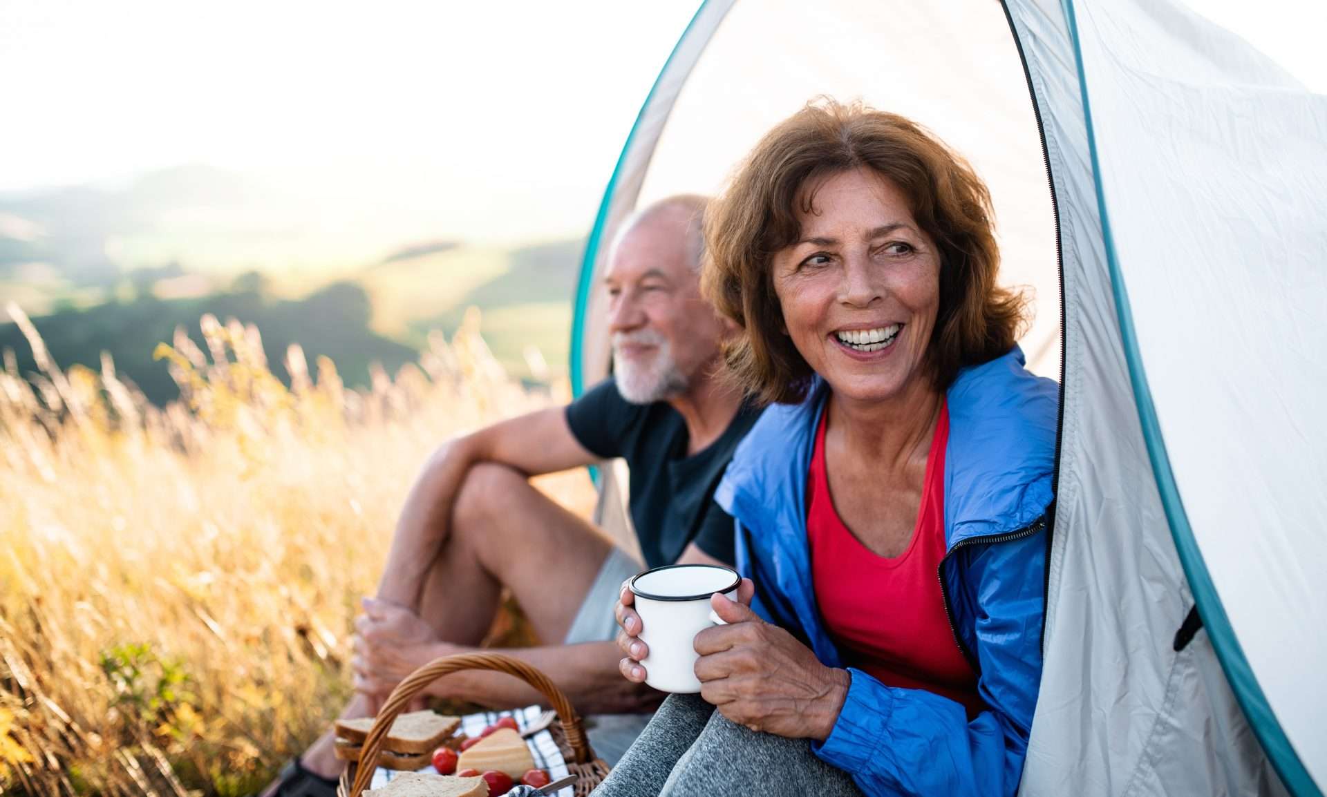 Older couple enjoying a picnic in a pop-up tent