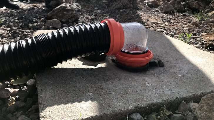 Close up of an RV sewer hose attached to dump station