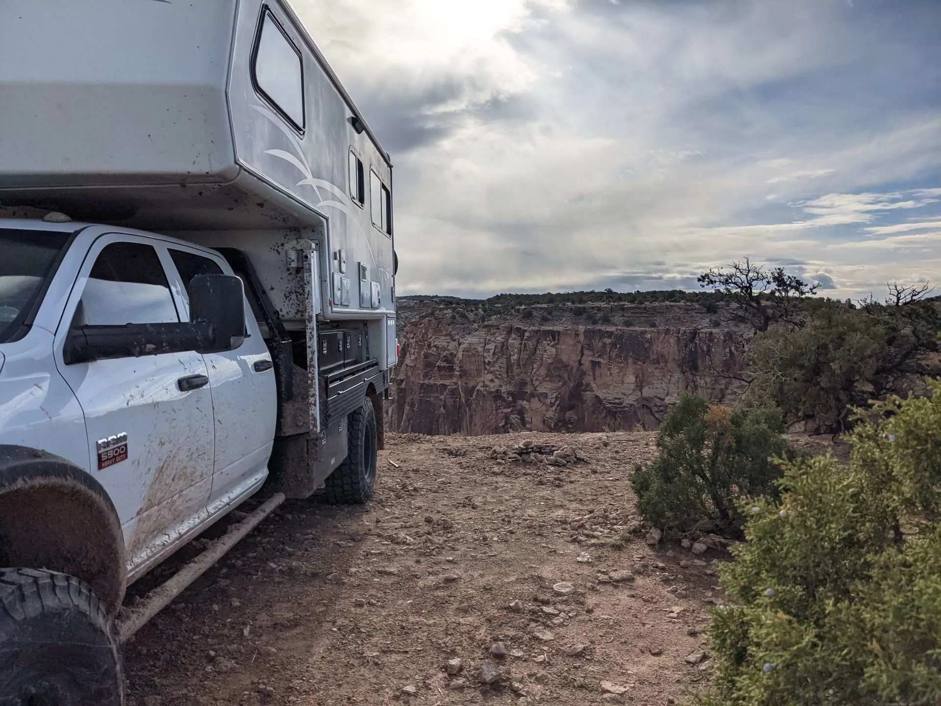 Truck camper parked next to cliff