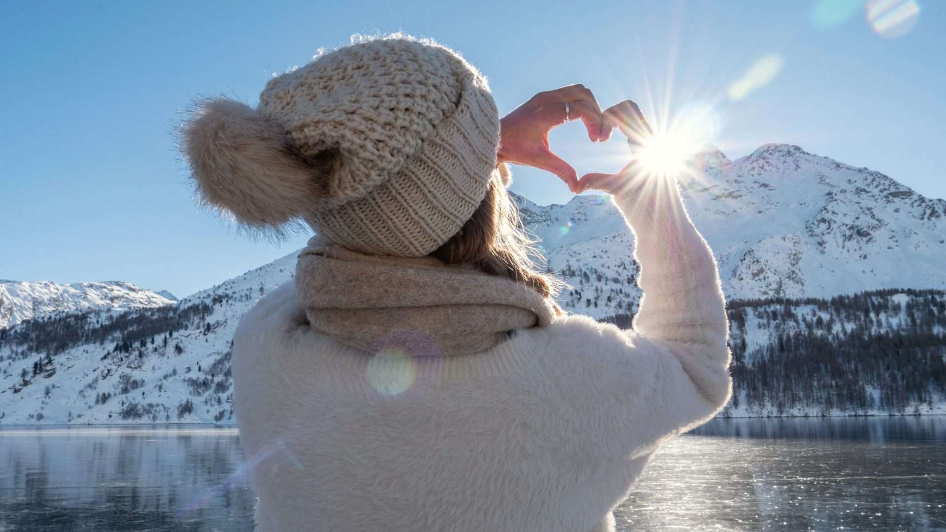 Woman dressed for winter making a heart sign with her hands